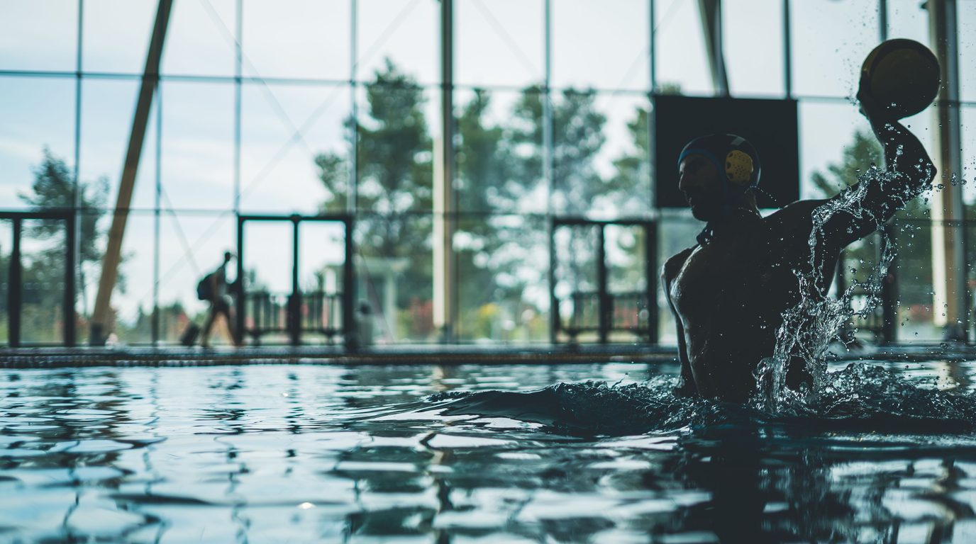Water polo player practising skills and ball handling in the pool