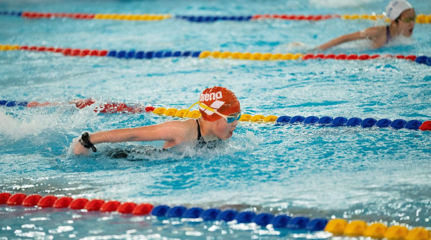 Junior swimmer racing butterfly stroke in a lane
